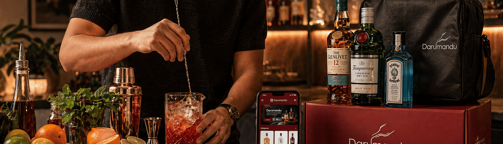 Here’s a clean, SEO-friendly **alt text** for your image: **Alt text:** A young adult crafting a cocktail at a cozy home bar using fresh ingredients and professional tools, with a Darumandu liquor delivery box, branded bottles, and a smartphone displaying the Darumandu app on a warmly lit kitchen counter at night. --- If you want a slightly more optimized version for SEO (blog use): **SEO alt text:** Home cocktail making scene with Darumandu online liquor delivery in Kathmandu, featuring a stylish bar setup, fresh ingredients, premium bottles, and a smartphone app interface in a warm, cozy kitchen environment.